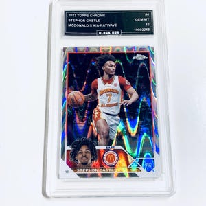 Peut inclure: Carte de basket-ball Stephon Castle McDonald's A/A-Raywave 2023 Topps Chrome, not&eacute;e GEM MT 10, dans un &eacute;tui de protection. La carte pr&eacute;sente un joueur en uniforme rouge et blanc dribblant un ballon, sur un fond holographique.
