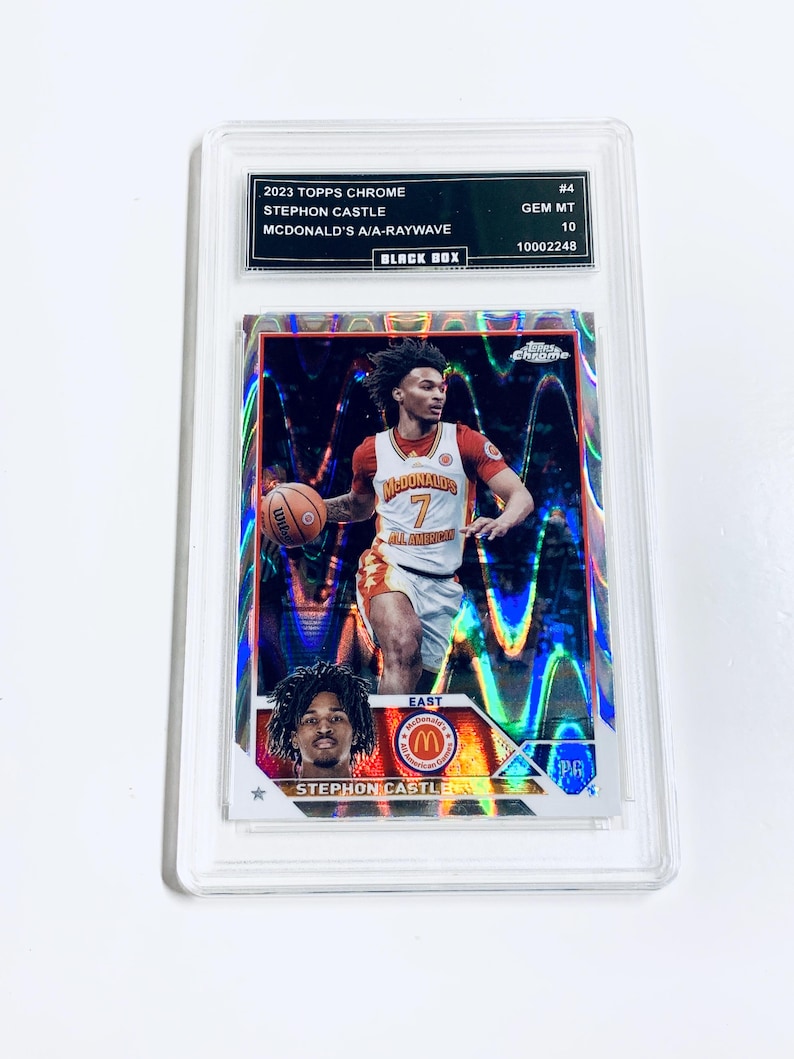 Peut inclure: Carte de basket-ball Stephon Castle McDonald's A/A-Raywave 2023 Topps Chrome, not&eacute;e GEM MT 10, dans un &eacute;tui de protection. La carte pr&eacute;sente un joueur en uniforme rouge et blanc dribblant un ballon, sur un fond holographique.