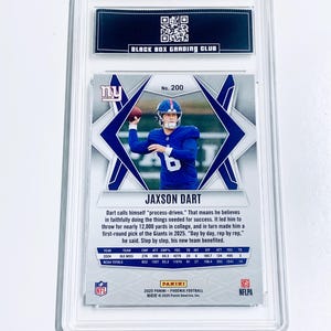 May include: A JAXSON DART football card, graded and encased in a protective holder. The card features a photo of the player in a blue uniform throwing a football. The card is from the 2025 Panini Phoenix Football series.