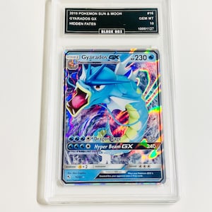 May include: A graded Pokémon card featuring Gyarados GX from the 2019 Sun & Moon Hidden Fates set. The card is encased in a clear protective holder with a black label indicating its condition and grade.