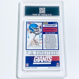 May include: A graded Jaxson Dart football card, featuring the New York Giants quarterback. The card is encased in a clear protective holder, with the "Black Box Grading Club" logo at the top. The card displays player stats and team information.