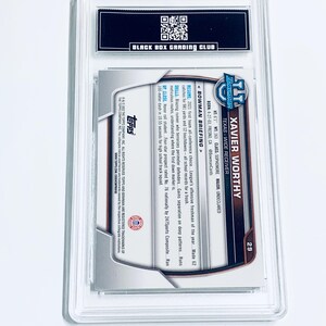 May include: A graded sports trading card featuring Xavier Worthy, a wide receiver from Texas. The card is encased in a clear plastic holder and includes text about the player's stats and achievements. The card is from the Bowman series.
