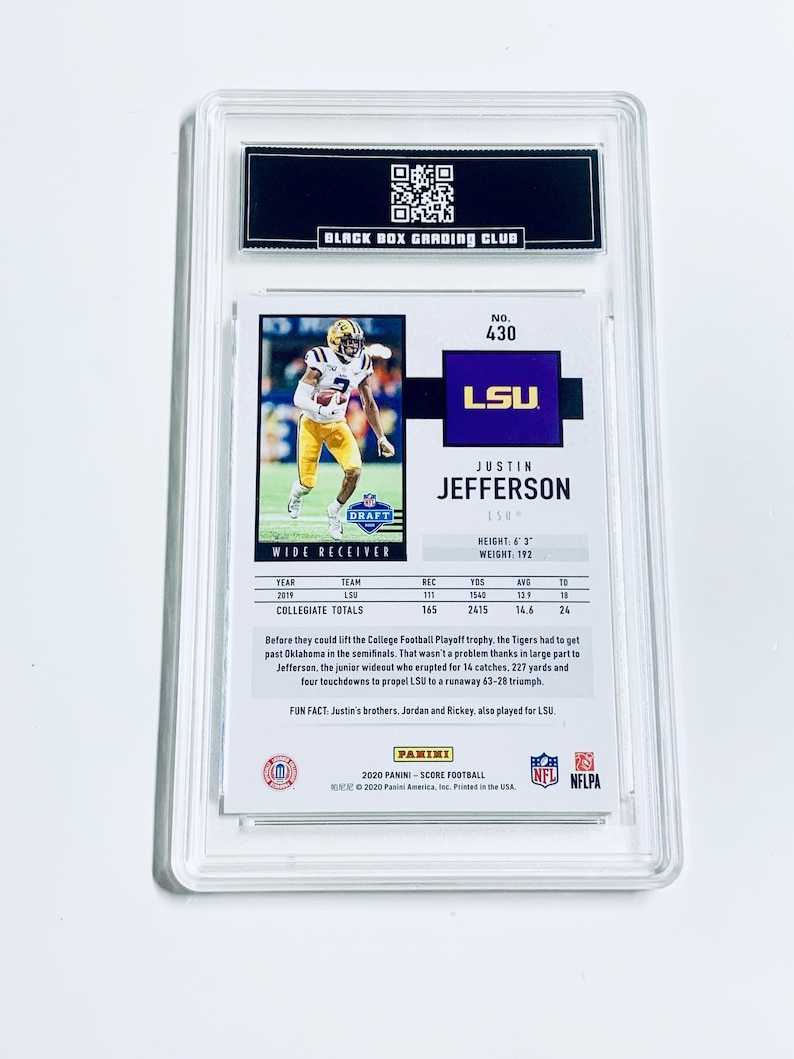 Op de afbeelding: Een beoordeelde Justin Jefferson voetbalkaart, met de speler in zijn LSU-uniform. De kaart is ingesloten in een doorzichtige beschermhouder, met het logo van de Black Box Grading Club bovenaan. De kaartdetails bevatten statistieken en een korte biografie.