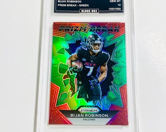 May include: A 2023 Prizm Bijan Robinson football trading card, graded GEM MT 10, featuring a player in action. The card has a green and red design with the text "PRIZM BREAK" and "BIJAN ROBINSON FALCONS".