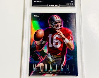 May include: A Joe Montana football card from the 2023 Topps Composite set, graded GEM MT 10. The card features Montana in a red jersey with the number 16, throwing a football. The card is encased in a protective holder with the text "MIDNIGHT".