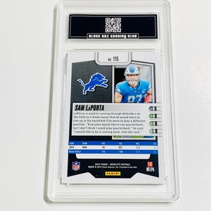 Peut inclure: Carte de football Sam LaPorta not&eacute;e, dans un &eacute;tui de protection transparent. La carte pr&eacute;sente le joueur en uniforme bleu et blanc. La carte comprend le nom du joueur, le logo de l'&eacute;quipe et les statistiques. S&eacute;rie Panini Absolute Football 2023.