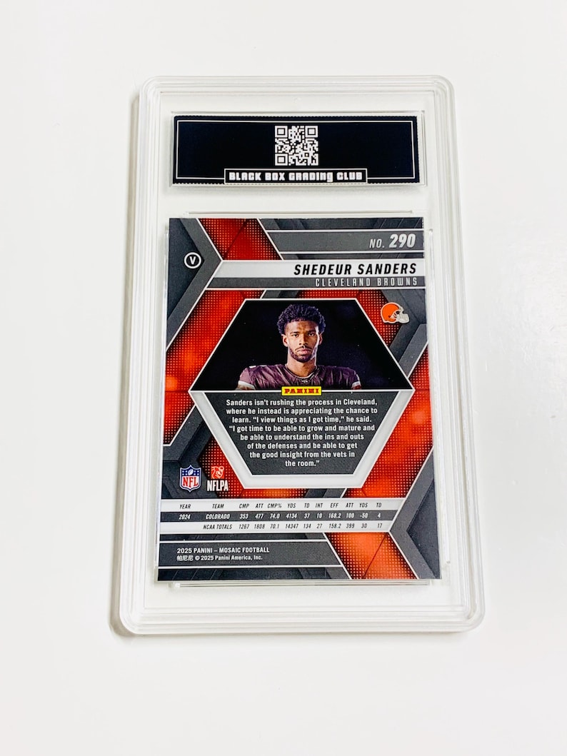Puede incluir: Una tarjeta de f&uacute;tbol calificada con Shedeur Sanders de los Cleveland Browns. La tarjeta tiene un dise&ntilde;o de mosaico con una foto del jugador. La tarjeta est&aacute; encerrada en un soporte protector transparente con el logotipo "Black Box Grading Club".