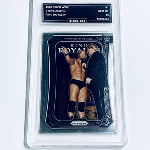 Puede incluir: Una tarjeta coleccionable Prizm WWE 2023 con Steve Austin, calificada GEM MT 10. La tarjeta presenta un diseño negro y plateado con el texto "RING ROYALTY" y "STONE COLD STEVE AUSTIN". La tarjeta está dentro de un protector.