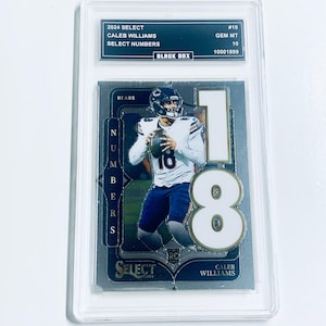 May include: A graded Caleb Williams football card from the 2024 Select series. The card features a photo of Williams in a Bears uniform, with the number 18 prominently displayed. The card is encased in a protective holder with the text "2024 SELECT" and "CALEB WILLIAMS".