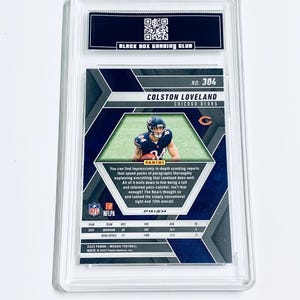 Puede incluir: Una tarjeta de f&uacute;tbol de Colston Loveland de los Chicago Bears, calificada y encapsulada en un soporte protector. La tarjeta presenta una imagen del jugador, el logotipo del equipo y estad&iacute;sticas. La tarjeta es de la serie 2025 Panini Mosaic Football.