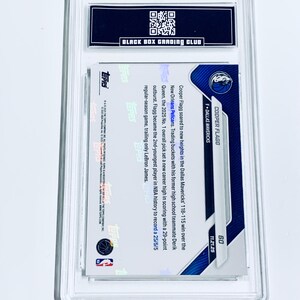 May include: A graded Cooper Flagg basketball card, encased in a clear protective holder. The card features the Dallas Mavericks logo and player information. The back of the card includes text about Flagg's performance.