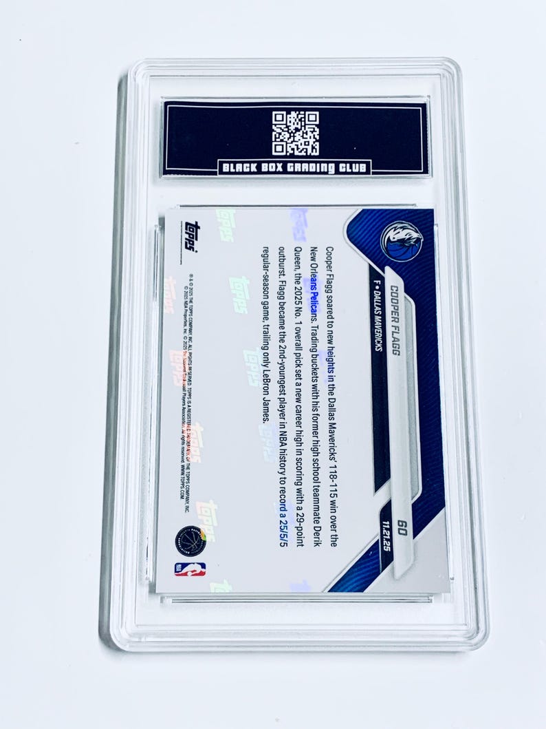 May include: A graded Cooper Flagg basketball card, encased in a clear protective holder. The card features the Dallas Mavericks logo and player information. The back of the card includes text about Flagg's performance.