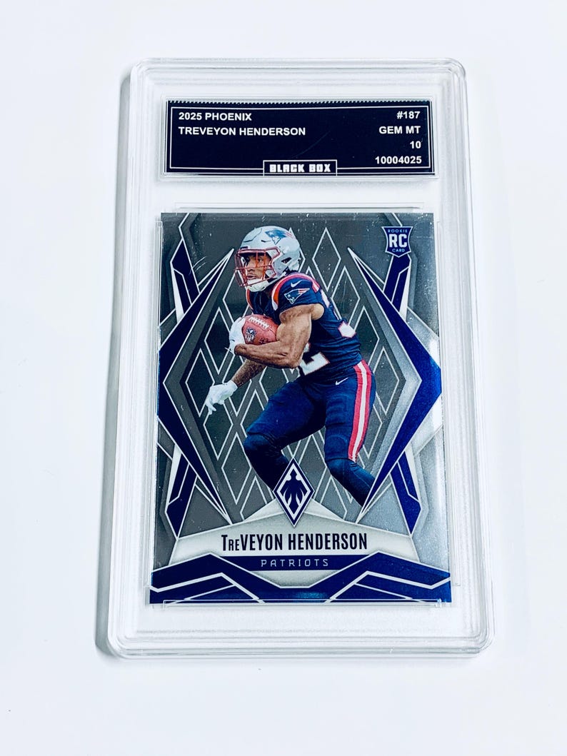 May include: A graded sports trading card featuring Treveyon Henderson of the Patriots. The card is from the 2025 Phoenix series and is graded GEM MT 10. The card has a silver and blue design with the player in action. The card is encased in a clear protective holder.