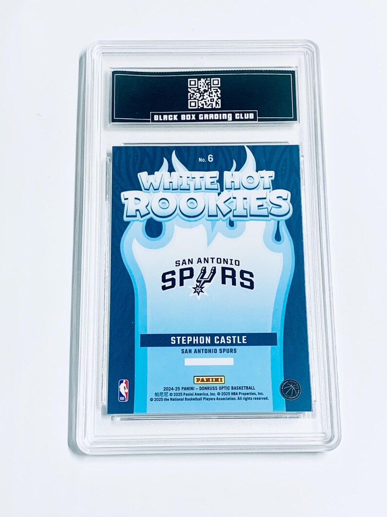 Może przedstawiać: Karta do koszyk&oacute;wki Stephon Castle San Antonio Spurs, oceniona z serii Panini Donruss Optic 2024-25. Karta jest zamknięta w przezroczystym plastikowym uchwycie przez Black Box Grading Club. Z tekstem "White Hot Rookies" i logo Spurs.