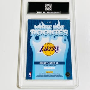 May include: A basketball trading card featuring Bronny James Jr. of the Los Angeles Lakers, part of the White Hot Rookies series. The card is encased in a clear protective holder, with the Panini and NBA logos visible.