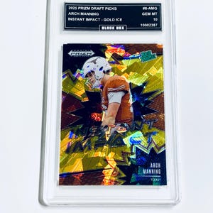 May include: A Prizm Draft Picks trading card featuring Arch Manning in a football uniform. The card is graded GEM MT 10 and encased in a protective holder. The card has the text "Instant Impact - Gold Ice" and "Texas".
