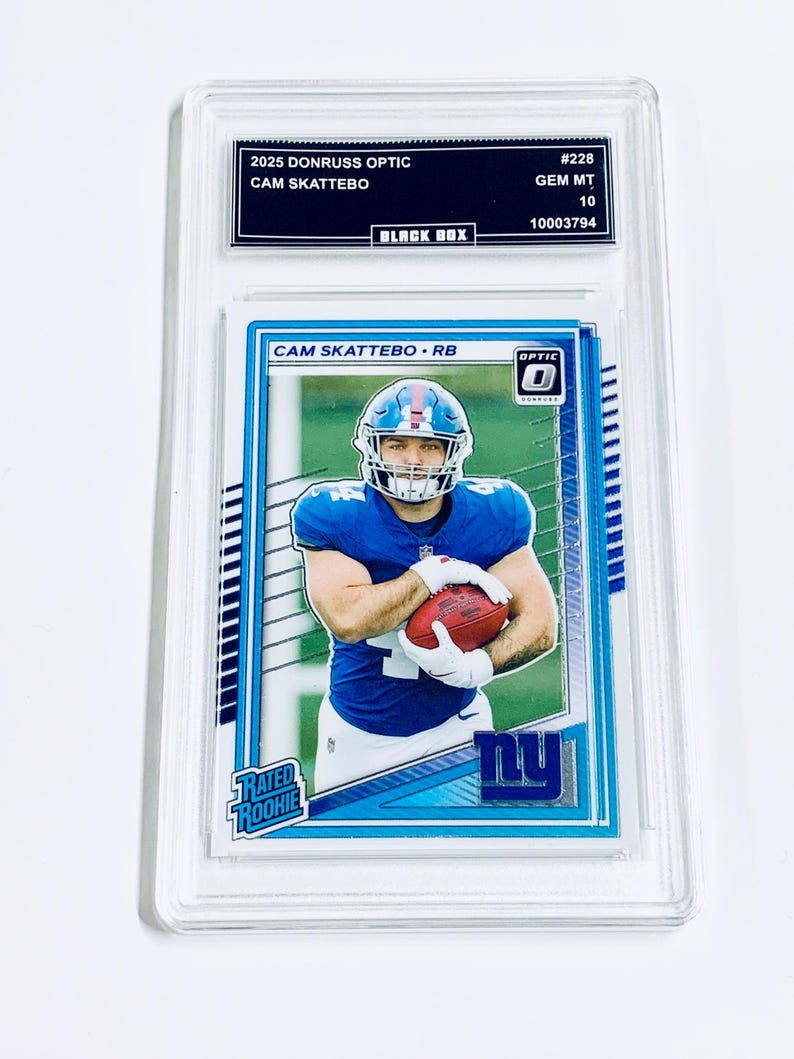 May include: A Cam Skattebo football card from the 2025 Donruss Optic series, graded GEM MT 10. The card features a player in a blue uniform holding a football. The card is encased in a protective holder.