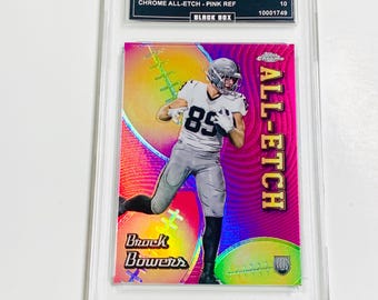 May include: A pink and chrome sports trading card featuring Brock Bowers in a football uniform. The card is labeled "2024 Topps Chrome" and "Chrome All-Etch - Pink Ref." The card is encased in a clear protective holder.