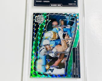 May include: A graded 2024 Mosaic Maxx Crosby football card. The card features a player in action with a green and silver mosaic design. The card is encased in a clear protective holder with the text "BLACK BOX".