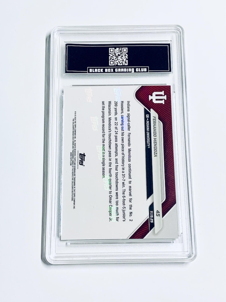 May include: A graded sports trading card encased in a clear plastic holder. The card features a maroon and white design with the name "FERNANDO MENDOZA" and "QB - INDIANA UNIVERSITY" printed on it. The card is from the Topps company.