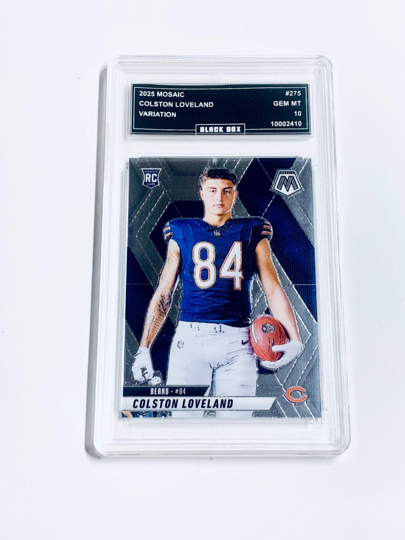 May include: A white ceramic mug with a black handle and the text "But First, Coffee" in a bold, black font. The mug is set against a blurred background, suggesting a cozy setting.