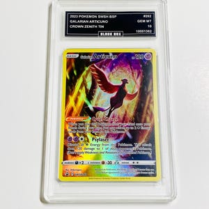 May include: A graded Pok&eacute;mon card featuring a Galarian Articuno with a colorful design. The card is encased in a clear protective holder with text that reads "2023 POKEMON SWSH BSP" and "CROWN ZENITH TIN". The card is labeled "GEM MT 10".