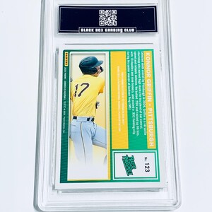 Puede incluir: Una tarjeta de b&eacute;isbol con Konnor Griffin de Pittsburgh, vistiendo una camiseta amarilla con el n&uacute;mero 17. La tarjeta est&aacute; dentro de un soporte protector transparente. La tarjeta tiene el texto "RATED PROSPECT" y "BLACK BOX GRADING CLUB".