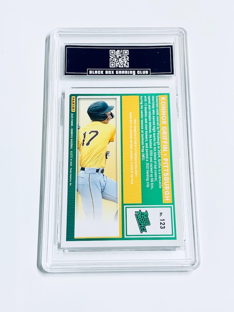 Puede incluir: Una tarjeta de b&eacute;isbol con Konnor Griffin de Pittsburgh, vistiendo una camiseta amarilla con el n&uacute;mero 17. La tarjeta est&aacute; dentro de un soporte protector transparente. La tarjeta tiene el texto "RATED PROSPECT" y "BLACK BOX GRADING CLUB".