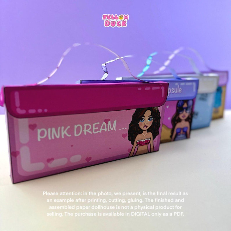 May include: A row of colorful paper dollhouse boxes. The front box is pink with the words "PINK DREAM" and a cartoon illustration. Other boxes are blue, silver, and purple. The Yellow Duck logo is in the top corner.
