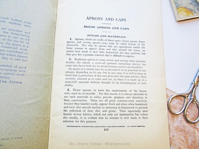 Puede incluir: Una p&aacute;gina de libro vintage con texto sobre delantales y gorros. El texto trata sobre los diferentes tipos de delantales y los materiales utilizados para hacerlos. El texto tambi&eacute;n menciona que los delantales son un amigo de la ama de casa y se pueden usar para diversos fines. La p&aacute;gina est&aacute; amarillenta por el paso del tiempo y tiene una est&eacute;tica vintage.