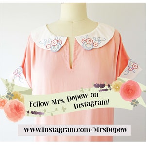 Puede incluir: Un vestido rosa con un cuello blanco y bordado floral. El vestido tiene mangas cortas y un escote en V. El vestido est&aacute; en un maniqu&iacute;. El texto "Follow Mrs. Depew on Instagram!" est&aacute; en una pancarta con flores. El texto "www.instagram.com/MrsDepew" est&aacute; debajo de la pancarta.