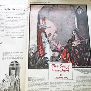 May include: A vintage magazine page featuring an illustration of a woman playing a guitar in a desert setting. The text reads "The Song in the Desert" by Charles Saxby. The magazine is from September 1923.