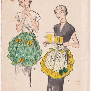 May include: An Advance 5423 sewing pattern envelope featuring illustrations of two aprons. One apron is green with a white floral print and yellow bows, while the other is white with green and yellow polka dots and a ruffled yellow border.