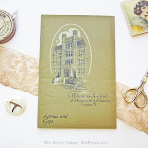 Puede incluir: Un folleto verde vintage con una ilustraci&oacute;n en blanco y negro de un edificio. El folleto se titula "Woman's Institute of Domestic Arts & Sciences Scranton, Pa." y "Aprons and Caps 405".