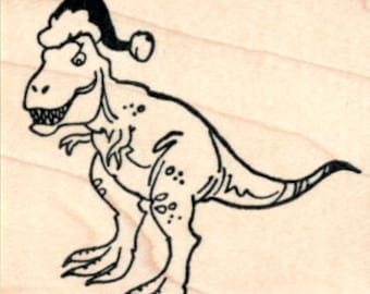 Puede incluir: Dibujo lineal en blanco y negro de un Tyrannosaurus Rex con un gorro de Papá Noel. El dinosaurio mira hacia la izquierda con la boca abierta, revelando los dientes. La imagen está sobre un bloque de madera, con una regla en la parte inferior.