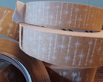 May include: Close-up of brown paper tape rolls with a white starburst pattern. The tape is designed for wrapping and sealing packages.