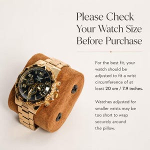 K&ouml;nnte beinhalten: Eine goldfarbene Analoguhr mit schwarzem Zifferblatt und Metallgliederarmband, befestigt auf einem braunen Kissen in Wildlederoptik. Der Text lautet: Please Check Your Watch Size Before Purchase. Die Uhr sollte f&uuml;r einen Handgelenksumfang von mindestens 20 cm angepasst sein.