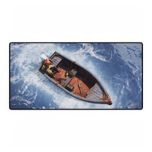 May include: A mousepad featuring a top-down view of a wooden boat floating on blue water. The boat has a motor, and a person is inside. The boat's interior is brown, and the water is a mix of blue and white.