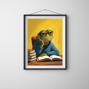 Peut inclure: Impression artistique encadrée d'une grenouille verte portant des lunettes et un pull bleu, posant son menton sur sa main. La grenouille est assise à un bureau en bois avec un livre ouvert et une pile de livres. Le fond est jaune.