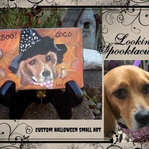 May include: A custom painted Halloween-themed small art piece featuring a dog wearing a witch hat. The dog is painted on a small square tile with a black background and the words "Boo!" and "Coco" are painted on the tile. The tile is on a small black stand.