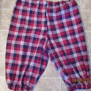 May include: Red, blue, and white plaid pajama pants with elastic waistband and cuffs.
