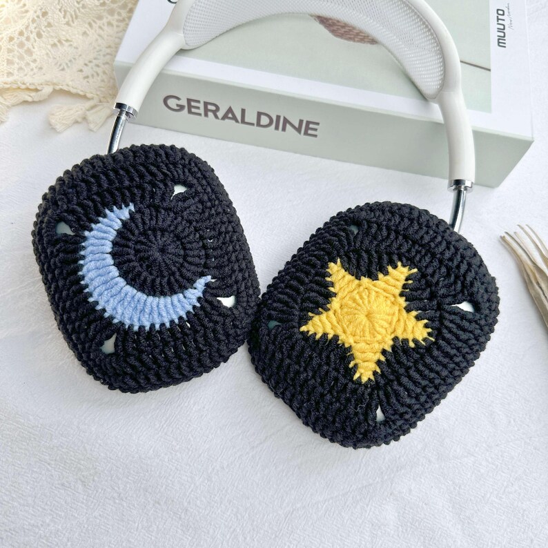 May include: Black crocheted headphone covers with a crescent moon and a yellow star design.