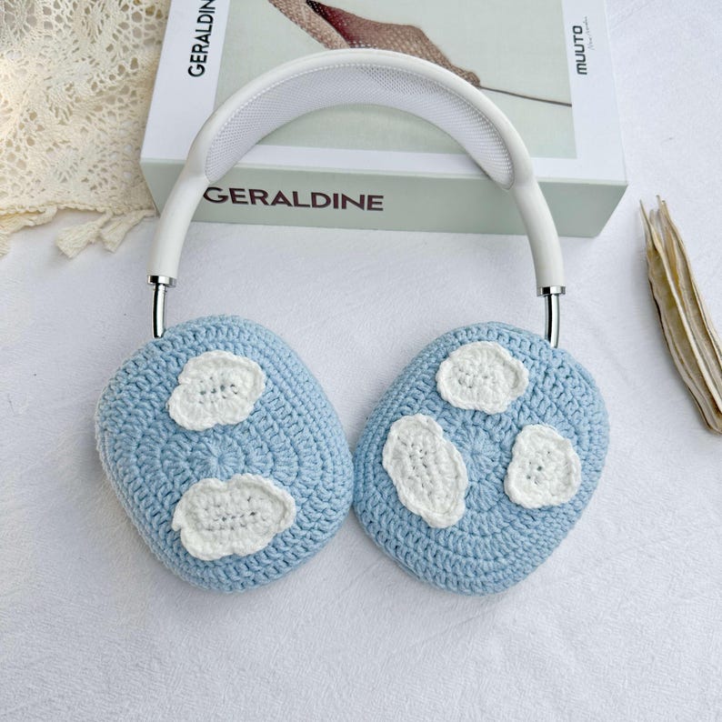 Puede incluir: Orejeras de crochet azul claro con detalles de flores de crochet blanco. Las orejeras est&aacute;n unidas a una diadema blanca.