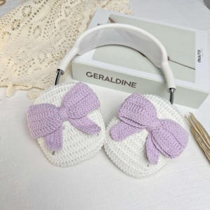 Puede incluir: Fundas para auriculares de crochet blanco con lazos morados. Las fundas est&aacute;n dise&ntilde;adas para ajustarse a los auriculares y tienen una textura suave y c&oacute;moda.