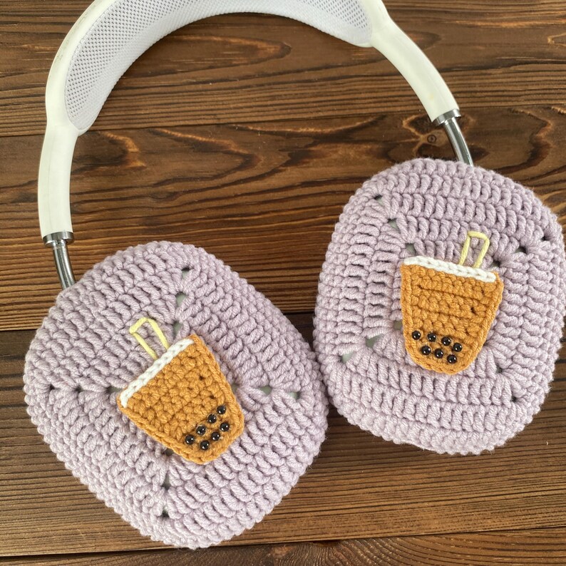 May include: Purple crocheted headphone covers with a brown and white crocheted boba tea design.