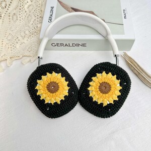 May include: Black crocheted earmuffs with sunflower designs. The earmuffs are attached to a white headband.