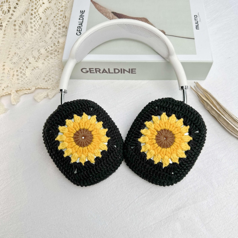May include: Black crocheted earmuffs with sunflower designs. The earmuffs are attached to a white headband.