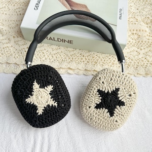 May include: Black and white crocheted headphone covers with a star design. The covers are made of a soft, textured yarn.