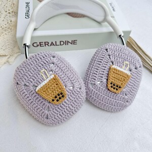 May include: Purple crocheted headphone covers with a brown and white crocheted boba tea design.