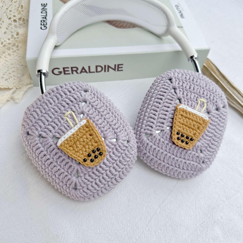 May include: Purple crocheted headphone covers with a brown and white crocheted boba tea design.